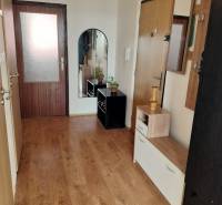 3 szobás lakás folyosója fa dekor padlóval és akasztós fallal.