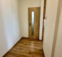 Garzonlakás fa dekor padlóval és üvegezett ajtóval.