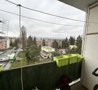 Kilátás egy háromszobás lakás erkélyéről az Október utcában, Eperjesen, parkoló és zöldterület.