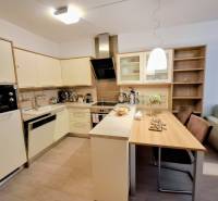 Konyha egy kétszobás lakásban étkezőasztallal és fa dekoros padlóval.