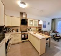 Konyha egy kétszobás lakásban konyhaszigettel és beépített készülékekkel.