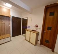 Előszoba kétszobás lakásban cipősszekrénnyel és fa dekorációs fogasfallal.