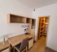 Íróasztal tárolóhelyekkel egy kétszobás lakásban, fa dekor padlóval.