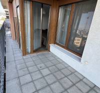 Erkély csempével és fa dekorációval, egy 2 szobás lakás része, korláttal és kilátással.