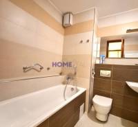 Fürdőszoba káddal, piszoárral és mosdóval egy kétszobás lakásban.