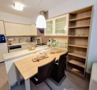 Konyhai tér egy kétszobás lakásban bárpulttal és beépített szekrényekkel.