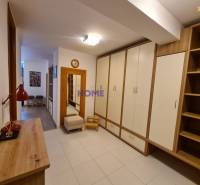 Folyosó tárolószekrényekkel és fa dekorációval egy kétszobás lakásban.