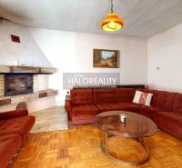 Nappali kandallóval és kanapéval egy családi házban, fa dekorációjú padlóval.