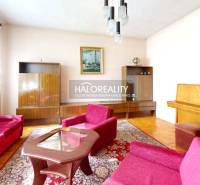 Nappali egy családi házban szőnyegmintával és fa dekorációjú padlóval.