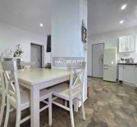 Konyha családi házban fa dekor padlóval és fehér bútorokkal.