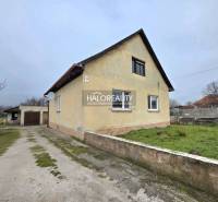 Családi ház Cseregyánban garázzsal, zöld gyepfelülettel és felhajtóval.