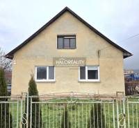 Családi ház Cserenyén egyszerű homlokzattal és kerítés mögötti előkerttel.