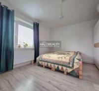 Hálószoba fa dekor padlóval, ággyal és beépített szekrénnyel egy családi házban.