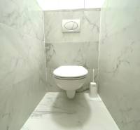 Fürdőszoba függesztett WC-vel és márvány burkolattal egy kétszobás lakásban.