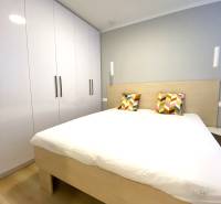 Hálószoba franciaággyal, színes párnákkal és szekrénnyel, 2 szobás lakás.