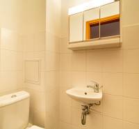 Fürdőszoba WC-vel, mosdóval és tükörrel egy háromszobás lakásban.