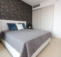 Hálószoba ággyal, mintás fal, fa dekorációjú padló, 2 szobás lakás.