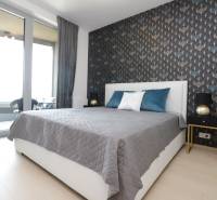 Hálószoba ággyal, tapétával és erkéllyel a kétszobás lakásban.