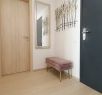 Előszoba egy kétszobás lakásban fa dekorációjú padlóval és paddal.