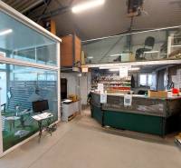 Üzlethelyiség üvegfallal és munkaterülettel, fa dekorációjú padlóval.