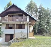 Házikó Borsky Svätý Jurban, zölddel és fákkal körülvéve, fa erkéllyel.