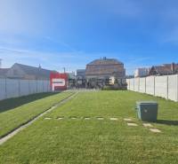 Kert a családi ház mellett a Horvát utcában, Szlovák Grobban, gyep és járda.