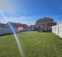 A Horvát utcai családi ház kertje Szlovák Grobban gyeppel és kerítéssel.