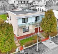 Családi ház Martinban lapos tetővel, kerttel és környező házakkal.