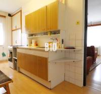 Konyha családi házban fa dekor padlóval, összekapcsolva a nappalival.