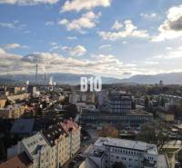 Zsolna városa panorámával, lakóházak és ipari zóna az előtérben.