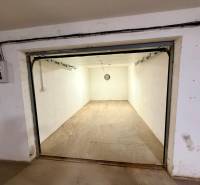 Üres garázsok betonpadlóval és egyszerű világítással.