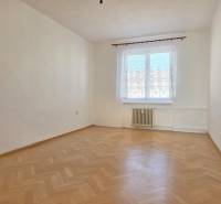 Üres szoba ablakkal és fa dekorációjú padlóval egy háromszobás lakásban.