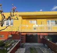 Családi ház Érsekújvár városában, Érsekújvár utcában, sárga homlokzattal és kerttel.