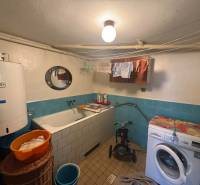 Fürdőszoba családi házban káddal, mosógéppel és bojlerrel, kék csempékkel.