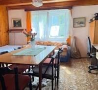 Nappali egy családi házban, étkezőasztallal és rajta virágokkal.