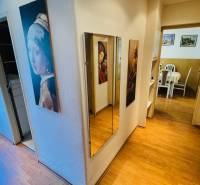 Előszoba tükörrel és fa dekorációjú padlóval egy háromszobás lakásban.