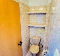 WC kerámia burkolattal és tároló polcokkal, a háromszobás lakás része.