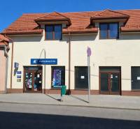 Kereskedelmi helyiségek a Krupina Obchodná utcáján ferde tetővel és kirakatokkal.