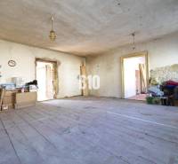 Rendetlen szoba egy családi házban, fa padlóval és építőanyaggal.