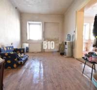 Nappali egy családi házban fa mintázatú padlóval, régebbi bútorokkal.