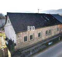 Családi ház Nagybiccseben kopott tetővel és vakolattal, főút mellett.