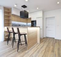 Konyha egy 3 szobás lakásban bárpulttal és fa dekoros padlóval.