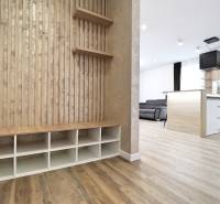 3 szobás lakás belső tere fa dekor padlóval, konyhával és nappali résszel.