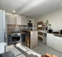 Konyha egy egyszobás lakásban világos belső térrel és ülőpulttal.