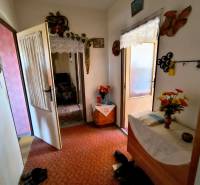 3 szobás lakás előszobája szőnyeggel, bútorokkal és dekorációként virágokkal.