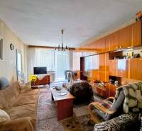 Nappali egy háromszobás lakásban, fa dekoros padlóval és ülőgarnitúrával.