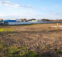 Kereskedelmi területek Vágkirályfán kiterjedt nyílt területtel és bekerített épületekkel.