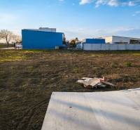 Kereskedelmi telkek Királyrévben, aszfaltos terület, épület és zöldterület.