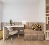 Dolgozósarok székkel, asztallal, paddal és polcokkal egy háromszobás lakásban.