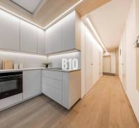 Konyha egy háromszobás lakásban fa dekor padlóval és világos bútorokkal.